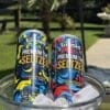 Two Binoid THC Seltzer cans—Blueberry Lemon Breeze & Berry Splash—in a glass bowl of ice outdoors