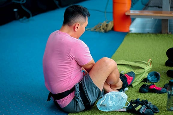 a man stretches muscles and joints for exercise on a mat.